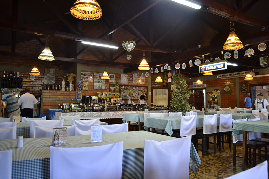 Salão interno com mesas postas e decoração alemã